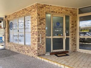external image of kinesiology clinic, light brick building with glass door